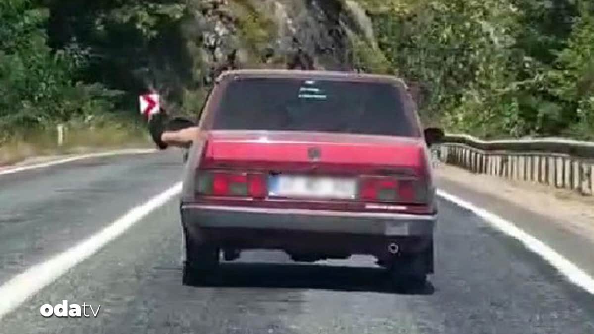 Ayaklarını camdan sarkıtarak trafiği tehlikeye attı Ayaklarını camdan sarkıtarak trafiği tehlikeye attı